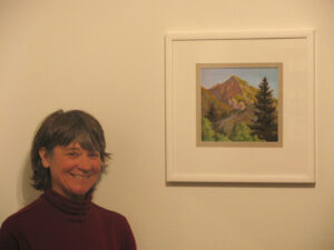 Artist Ane Carla Rovetta with one of her paintings in the Mono Lake Committee gallery. Photo by Arya Degenhardt.