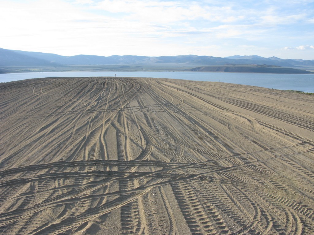 A lone person stands at the end of the earthworks, looking over Mono Lake