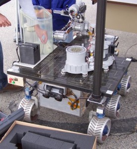 The reddish sand in the wheels is from JPL's indoor sand box--actually crushed garnet which minimizes dust--where the rover is tested. There is also an outdoor terrain park where final testing is done. Photos by Greg Reis.