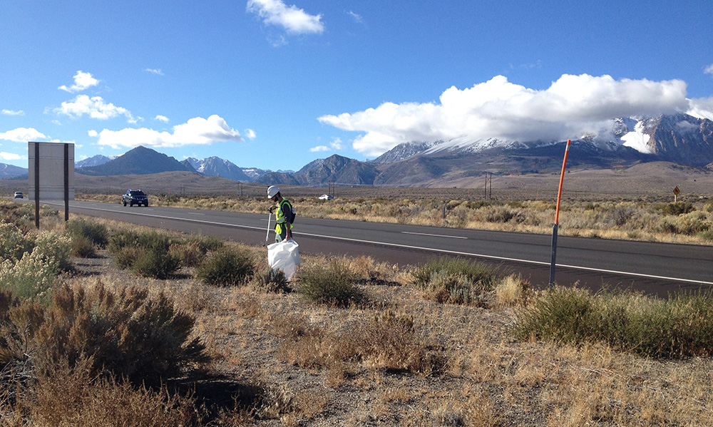 Robbie picking up litter along Highway 395. Photo by Andrew Youssef.