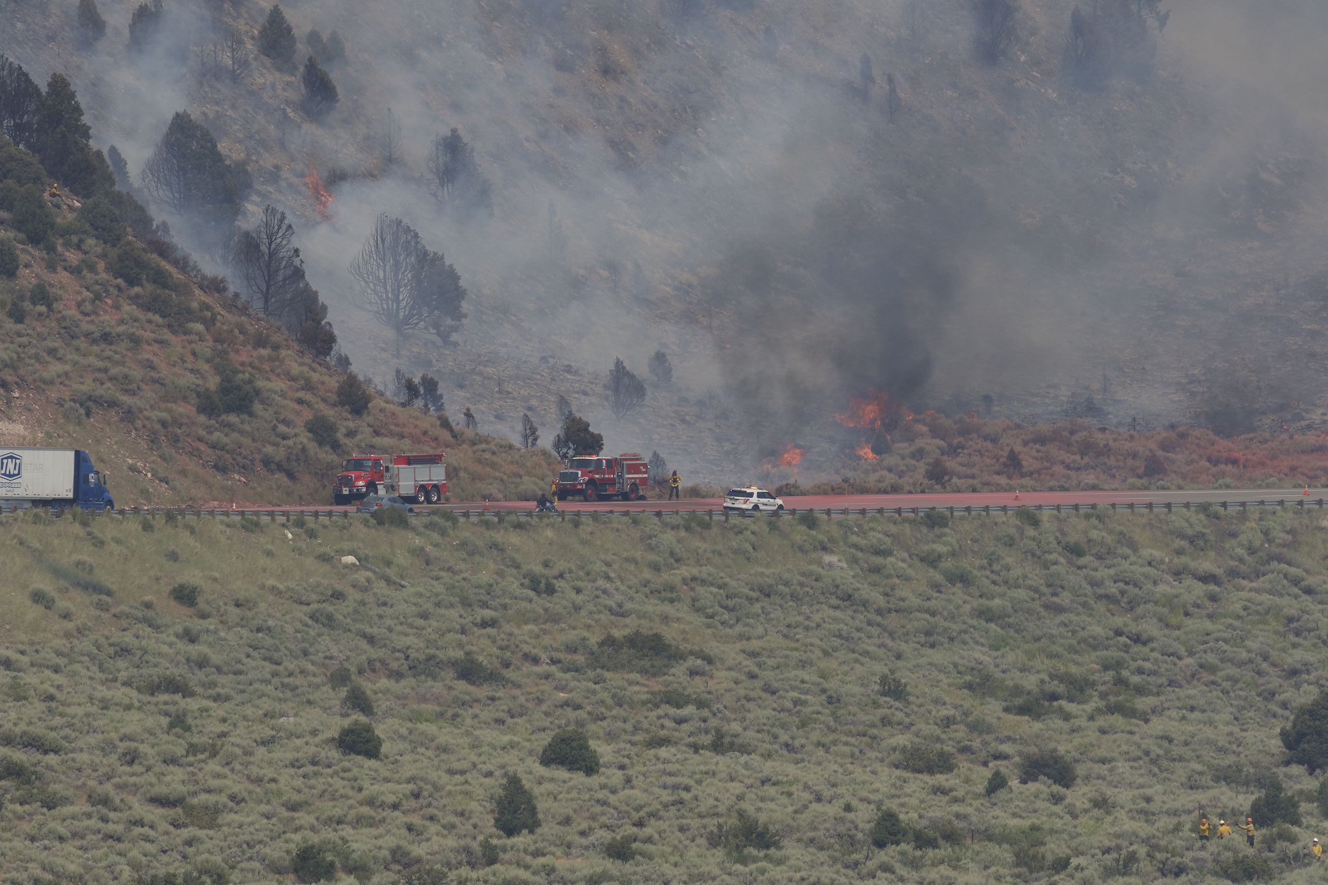 Fire personnel on Highway 395 and monitoring from below. Red coloration on the highway is fire retardant. Photo by Santiago M. Escruceria.
