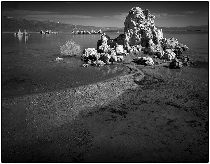 A tufa sits at the end of a curve of shoreline of Mono Lake.