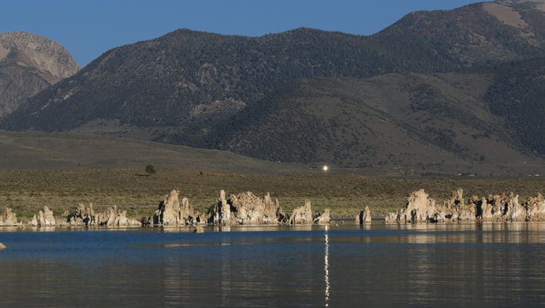 Reflection from a mirror up on the hill at the site of the Tioga Inn development project with the reflection casting a bright white line across Mono Lake.