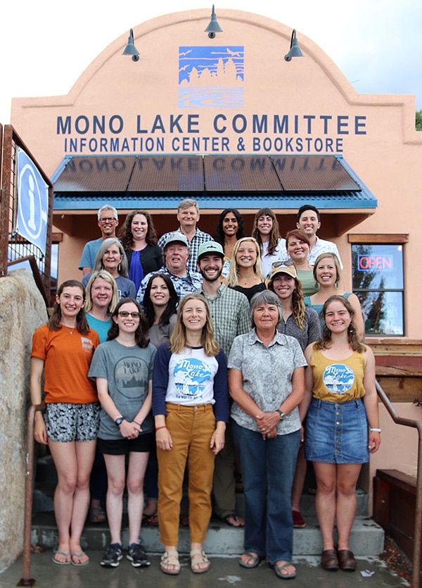 Twenty people stand together for a group photo on the steps on the Mono Lake Committee Information Center & Bookstore.