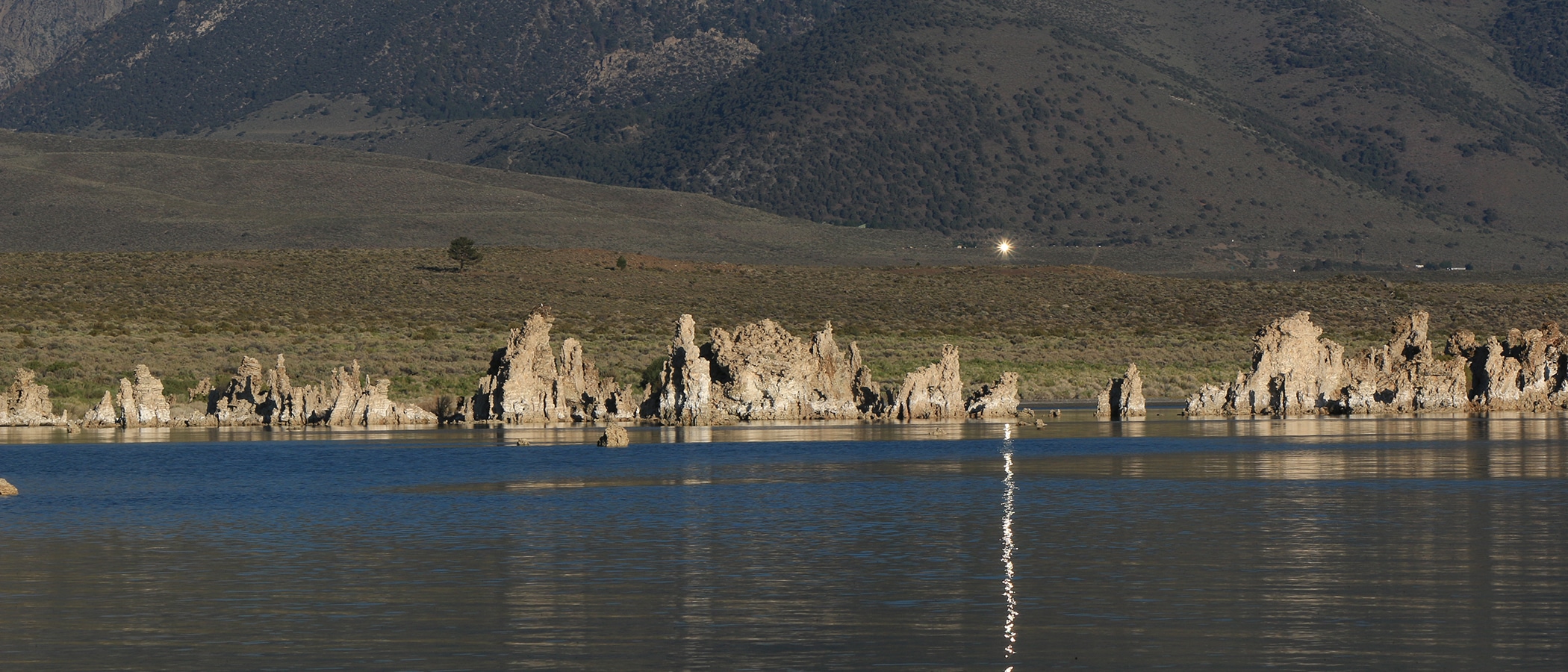 Reflection from a mirror up on the hill at the site of the Tioga Inn development project with the reflection casting a bright white line across Mono Lake.