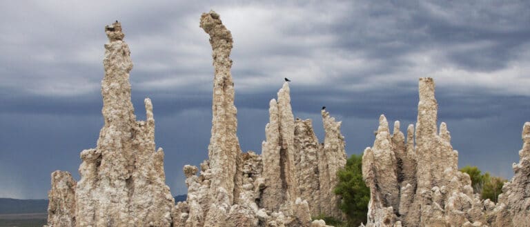 Tall, thin tufa towers reach into the gray-blue sky above.