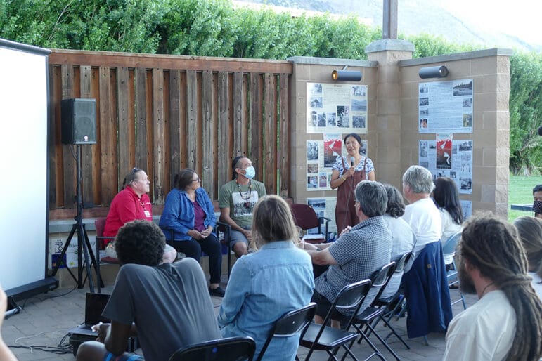 A panel of 4 talking to seated crowd.