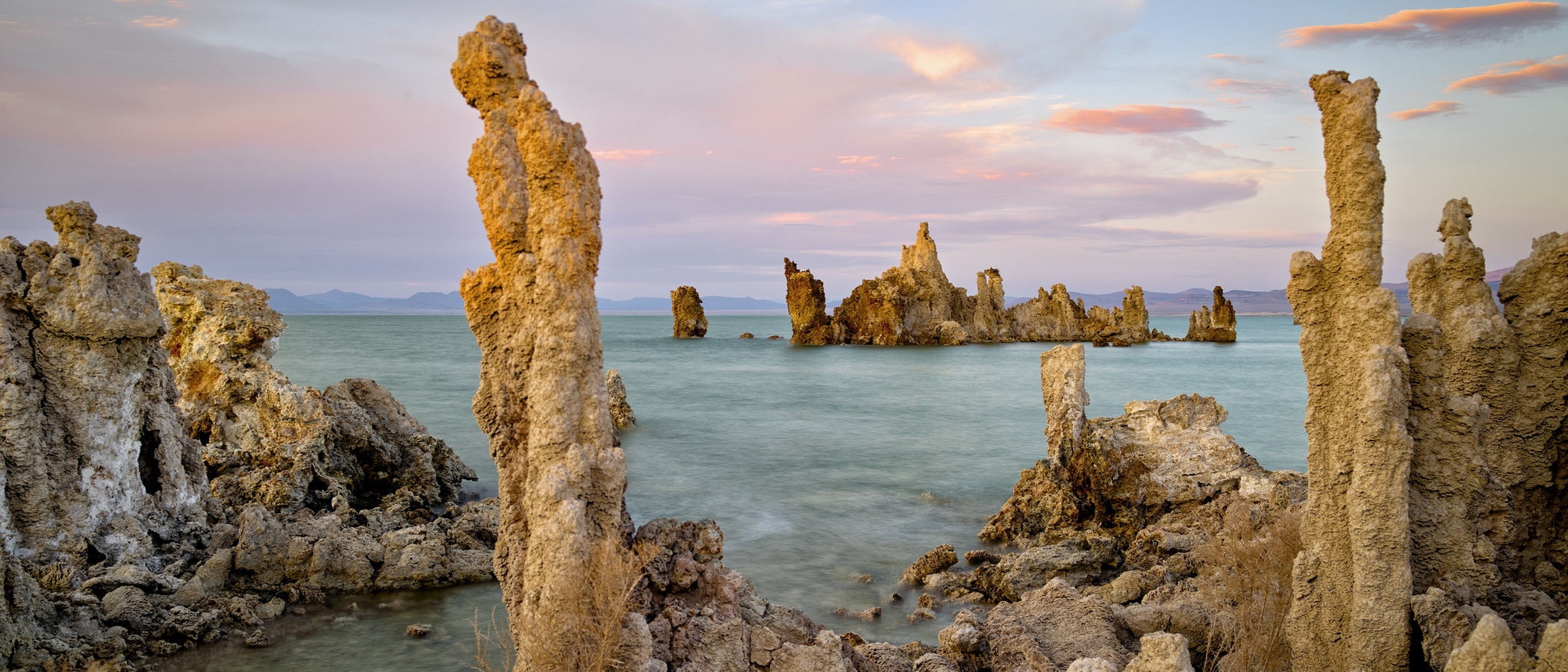 Tufa on the shore of Mono Lake with pink sunset clouds on the horizon.