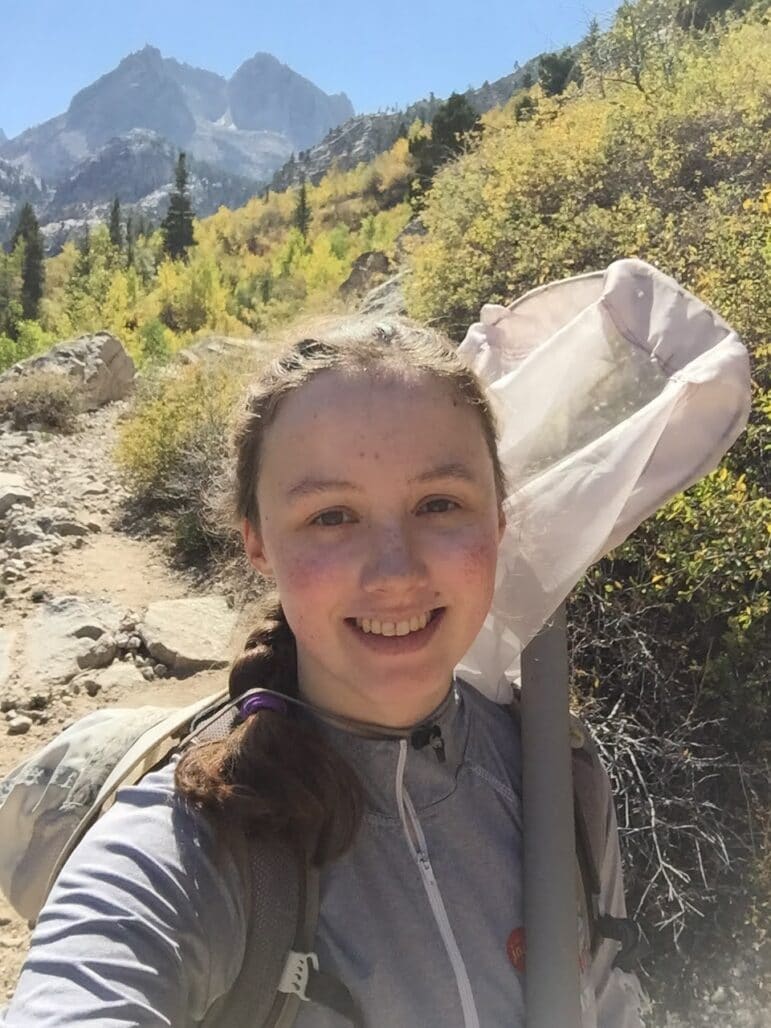 Jen Bayer of Silicon Valley Barcode of Life carrying a collection net on a mountain trail.